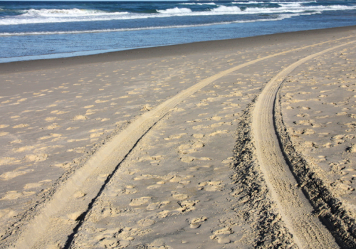 Huellas vehículos en playa